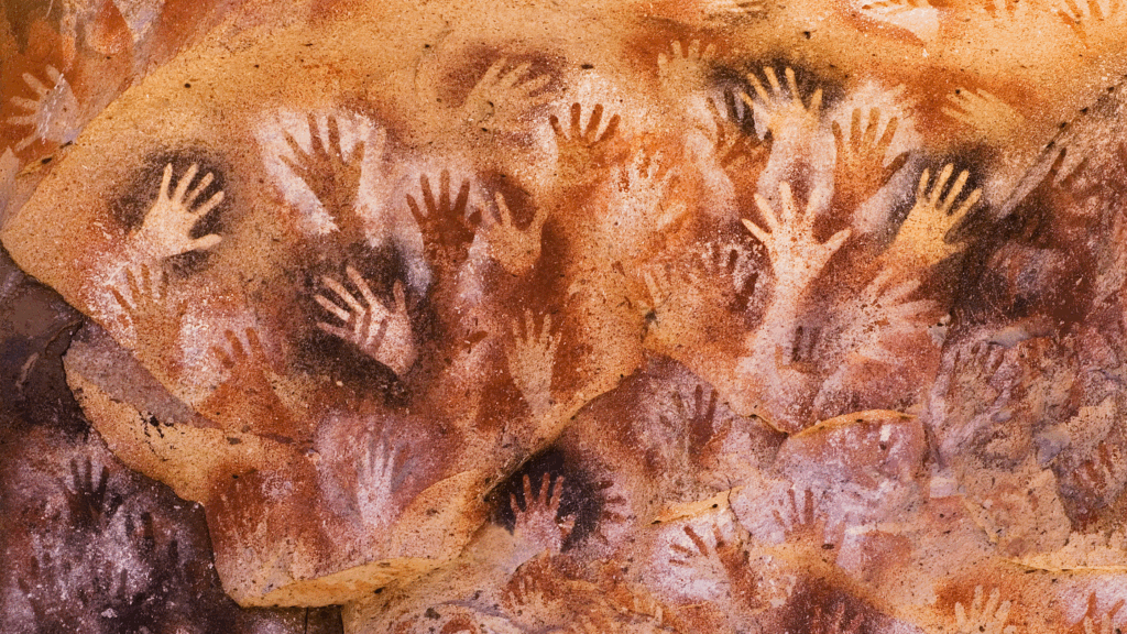 mural de arte parietal prehistórico con siluetas de manos superpuestas