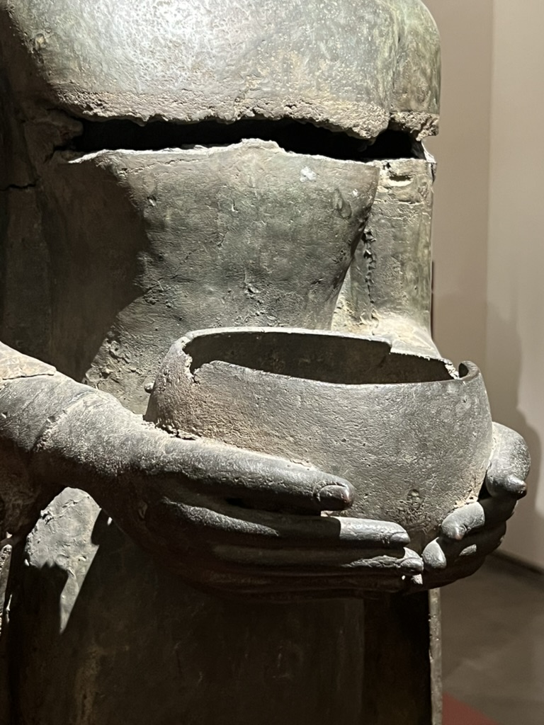 escultura con cuenco en las manos